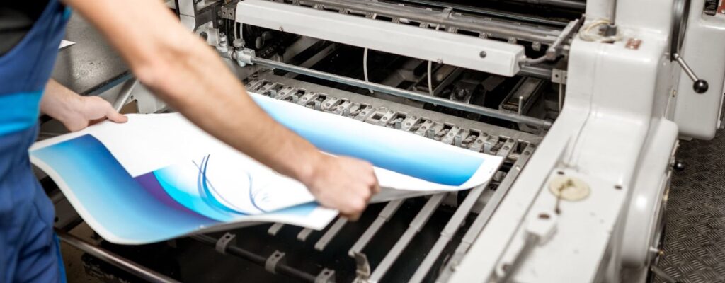 A man printing architectural plans on a wide-format printer